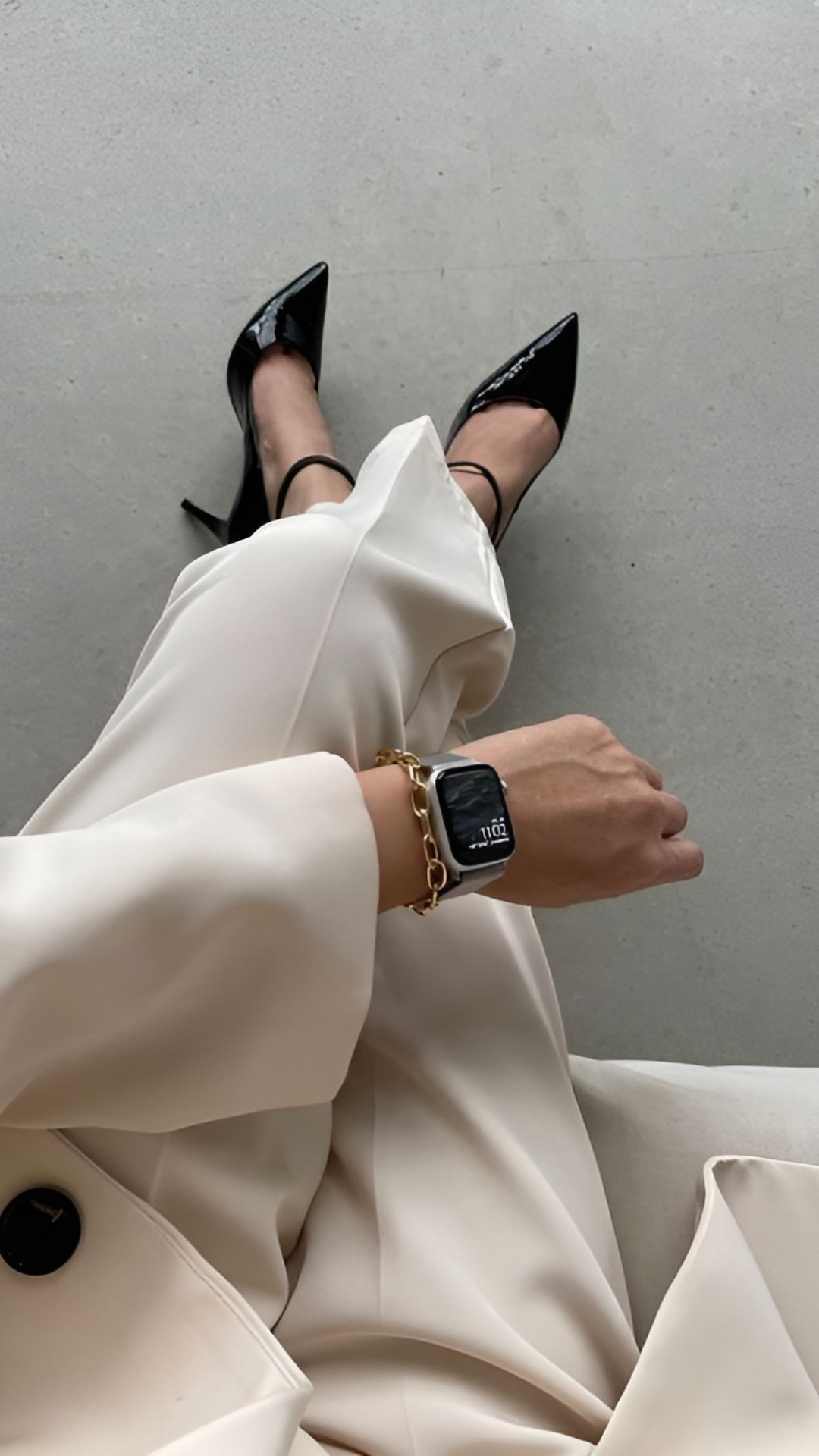 Boss woman in a tailored white suit with black heels and a smart watch